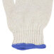 A pair of white Cordova work gloves with blue trim on the wrist.
