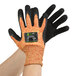A pair of medium Cordova orange and black gloves with black sandy nitrile palms.
