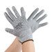 A pair of hands wearing Cordova gray and white gloves.