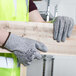 A person wearing Cordova Valor safety gloves holding a piece of wood.