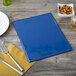 A blue Menu Solutions Hamilton menu board with a fork and knife next to a plate and napkin.