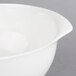 A close-up of a Villeroy & Boch white porcelain salad bowl with a handle.