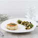 A Villeroy & Boch white porcelain flat plate with a crab cake and vegetables on it.