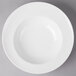 A Villeroy & Boch white porcelain pasta plate with a white rim on a gray surface.