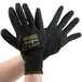 A pair of extra large Cordova Monarch black gloves with black latex palm coating and yellow and black markings.
