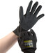 A hand wearing a large black and grey Cordova Monarch work glove.