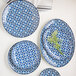 A group of white porcelain brunch plates with blue floral designs on a table.