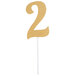 A gold glittery number 2 cake topper on a stick.