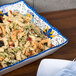 A Santa Lucia melamine tray with pasta, vegetables, and olives.