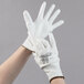 A pair of hands wearing Cordova white gloves with white polyurethane palms.