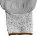 A close up of a Cordova Caliber warehouse glove with gray and white fibers and brown trim.