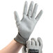 A close-up of a hand wearing a gray and white Cordova Monarch work glove.
