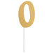 A gold glitter "0" cake topper on a white background.