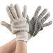 A pair of hands wearing Cordova economy weight work gloves with black PVC dotted palms.