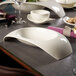 A Villeroy & Boch white porcelain bowl with a curved edge on a table.