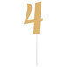 A gold number 4 cake topper on a white stick.