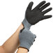 A pair of hands wearing Cordova gray gloves with black crinkle latex palms.