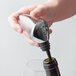 A person using a Rabbit aerating wine pourer to pour wine from a bottle.
