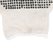 A close-up of Cordova white knit work gloves with black dots on them.