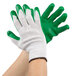 A pair of hands wearing Cordova warehouse gloves with green latex palms.