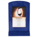 A blue wooden framed Menu Solutions table tent on a table with a wine glass in it.