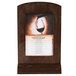 A Menu Solutions walnut wood menu tent on an angled base on a table with a glass of wine.