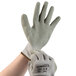 A hand wearing a pair of Cordova gray polyester/cotton gloves with a gray crinkle latex palm coating.