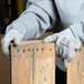 A person wearing Cordova Cor-Grip II gloves holding a piece of wood.