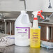 A white 32 oz. bottle with a purple label for "Noble Chemical Lemon Lance Disinfectant & Detergent Cleaner" on a counter.