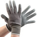 A pair of Cordova gray nylon gloves with gray polyurethane palms on a pair of hands.