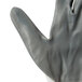 A close-up of a Cordova white nylon work glove with gray nitrile coating.