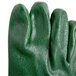 A close up of a Cordova green rubber glove with black trim on the thumb.
