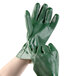 A pair of hands wearing Cordova green PVC gloves with jersey lining.