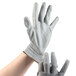 A pair of hands wearing gray Cordova warehouse gloves.