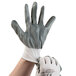 A hand wearing a Cordova white nylon glove with grey nitrile coating.
