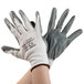 A pair of hands wearing Cordova white nylon gloves with gray nitrile palm coating.