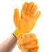 A person's hands wearing Cordova orange warehouse gloves with criss-cross PVC coating.