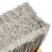 A close up of a Carlisle push broom head with gray flagged bristles.