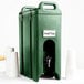 A green plastic Cambro Camtainer insulated beverage dispenser with a metal lid.