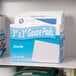A box of Medi-First sterile 3" x 3" gauze pads on a shelf.