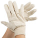 A pair of hands wearing Cordova medium weight cotton canvas gloves.
