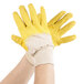 A pair of hands wearing yellow Cordova Ruffian gloves with canvas lining.