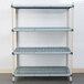 A white MetroMax Q metal shelving unit with blue shelves and a white grid.