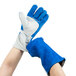 A pair of Cordova blue and white leather welder's gloves on a pair of hands.