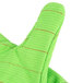 A close up of a lime green Cordova work glove with orange accents.
