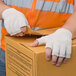 A person wearing Cordova fingerless gloves opening a box.