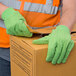 A person wearing Cordova Hi-Vis lime jersey work gloves opening a box.