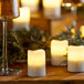 Sterno Rechargeable Flameless Votive candles on a table with wine glasses.