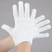 A pair of hands wearing Cordova medium weight white work gloves.