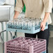 A gray Noble Warewashing 20-compartment full-size glass rack holding multiple clear glasses.